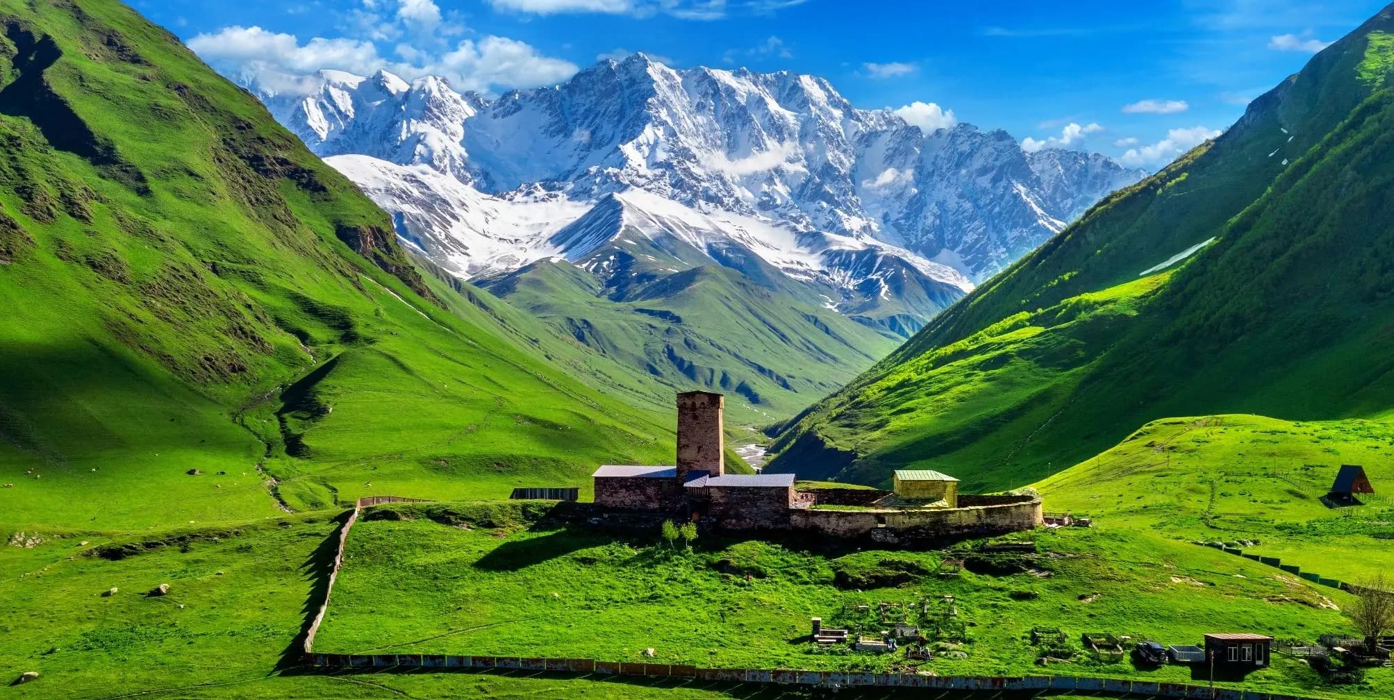 Stone church beneath snow-capped peaks in the Georgian Caucasus